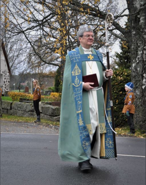 Piispa Kaarlo Kalliala kävelee Liedon kirko edustalla